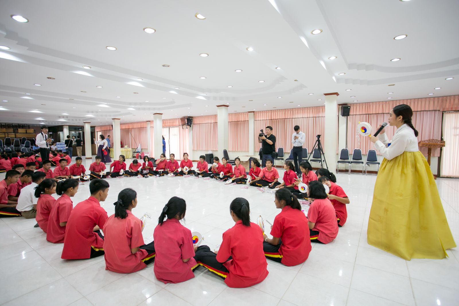 수판부리의 우텅학교 학생들이 서울대학교 국악학과 학생의 시범에 따라 주태국 한국문화원에서 선물한 소고를 직접 체험해보고 있다. 