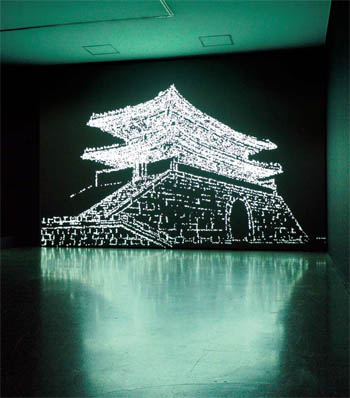 문경원은 이번 전시에서 국보 1호인 숭례문의 웅장한 위엄을 보여준다. 파편들이 흩어졌다 모이면서 여러 각도에서 바라본 숭례문의 모습이 탄생하고, 이는 시간의 흔적을 다시금 생각해보는 기회를 마련한다 (사진: 국립현대미술관).