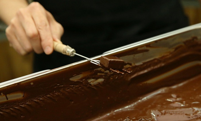 홍경천 장인이 초콜릿 제조과정 가운데 초콜릿을 한 겹 덧입히는 ‘딥핑(dipping)'을 보여주고 있다.