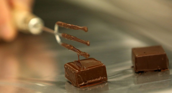 홍경천 장인이 초콜릿 제조과정 가운데 초콜릿을 한 겹 덧입히는 ‘딥핑(dipping)'을 보여주고 있다.