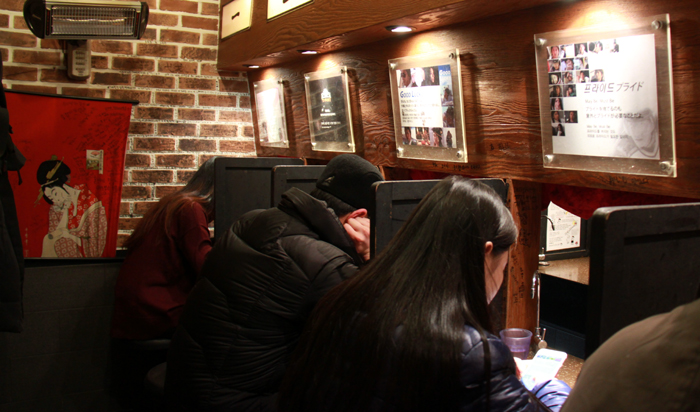 Solo diners seated in partitioned one-person ramen booths in Seoul