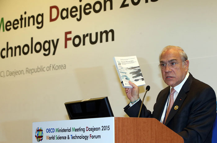 앙헬 구리아 OECD 사무총장이 19일 대전 세계과학기술포럼 특별세션에서 '과학산업기술 스코어보드' 2015년판 등이 담긴 OECD 발간물을 소개하고 있다.