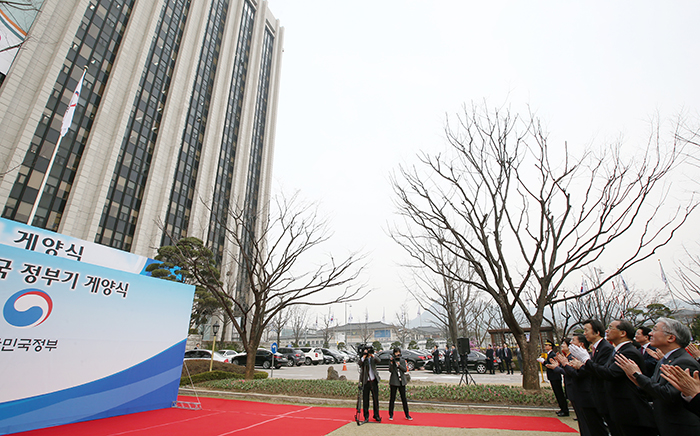 29일 정부서울청사에 모인 각 부처 장관들과 관계자들이 지켜보고 있는 가운데 새로운 대한민국 정부기가 게양되고 있다.