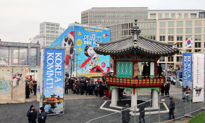 25일 베를린 포츠담 광장에서 열린 '통일정' 준공식에서 방문객들이 통일정 앞에서 사진을 찍고 있다.