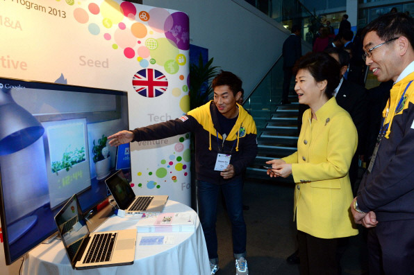 박근혜 대통령(오른쪽 두번째)이 한-영 창조경제 포럼 개막식 후 열린 전시회에서 한 벤처기업의 제품을 시연하고 있다. (사진: 청와대)