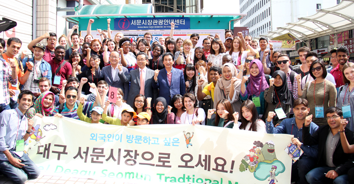 ‘전통시장 외국인 유랑단’ 단원들이 19일 ‘대구 서문시장으로 오세요’라고 적힌 플래카드를 펼쳐보이며 기념촬영을 하고 있다.