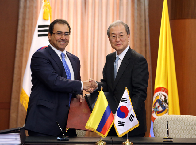 박태호 통상교섭본부장(오른쪽)과 세르히오 디아스-그라나도스(Sergio Diaz-Granados) 콜롬비아 통상산업관광장관(Minister of Trade, Industry and Tourism) 이 21일 오전 외교통상부에서 양국 FTA에 정식 서명한 뒤 서명서를 교환하며 악수하고 있다. (사진: 연합뉴스)