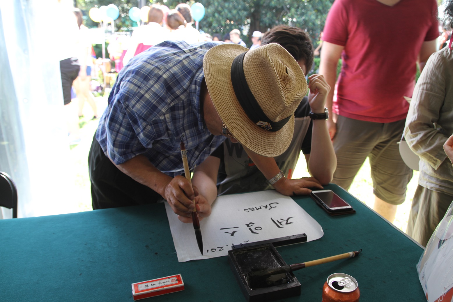 문화 체험 부스를 찾은 관람객이 한글 서예로 이름을 적고 있다.