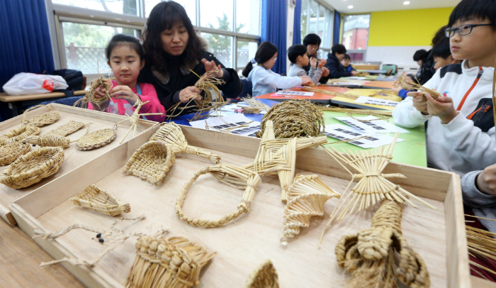 국립민속박물관에서 열린 겨울방학 프로그램에서 전통 짚풀 공예를 체험하는 어린이들 (사진: 연합뉴스)
