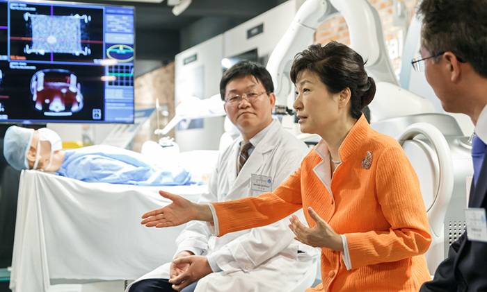 박근혜 대통령이 15일 울산창조경제혁신세터 의료자동화 생태존에서 암세포를 진단하고 치료하는 자동화 장비를 살펴 본 뒤, ‘의료자동화산업’에 대해 서준범 서울아산병원 교수, 김진국 코어라인소프트 대표 등과 이야기를 나누고 있다.