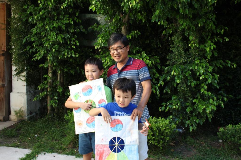 전시 기획자이자 참여 작가인 조용화 작가가 워크숍을 진행하며 아이들과 함께 만든 연을 들고 사진을 찍었다.