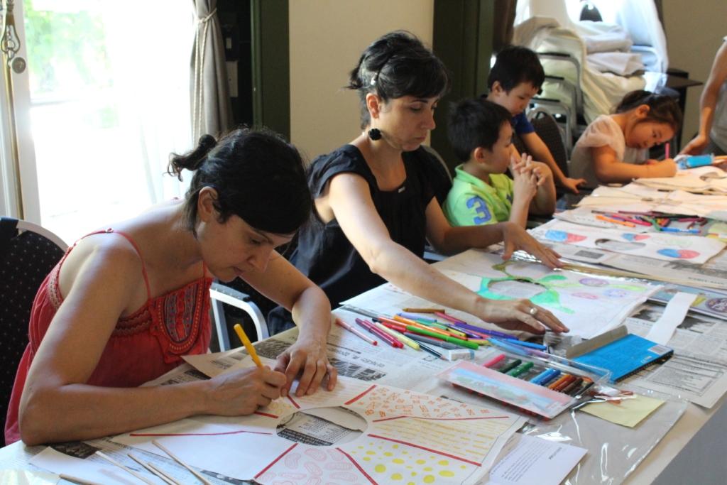 워크숍 참가자들이 진지한 표정으로 연 종이에 그림을 그리고 색을 칠하고 있다.