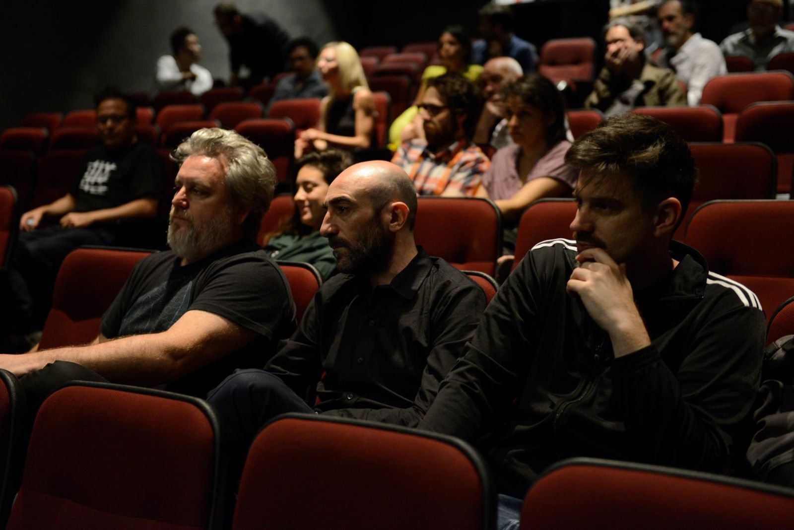 아르헨티나 관객들이 16mm 영사기 필름이 재현하는 한국의 역사적 자취를 담은 영상에 알란 코루티스의 즉흥 기타 연주를 감상하고 있다.