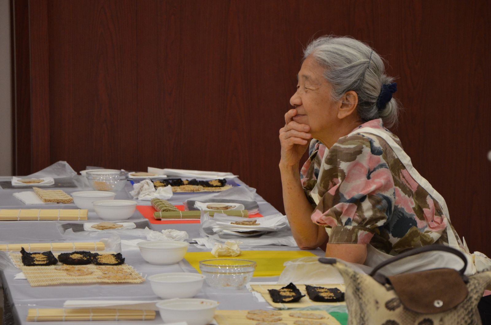 부각 만들기 체험 행사를 즐기고 있는 중후한 연령대의 참가자의 여유로운 웃음.