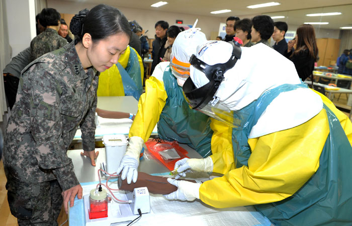 국군간호사관학교 관계자들이 에볼라 대응 긴급구호대원들의 실전대비 교육훈련을 재연하고 있다. 