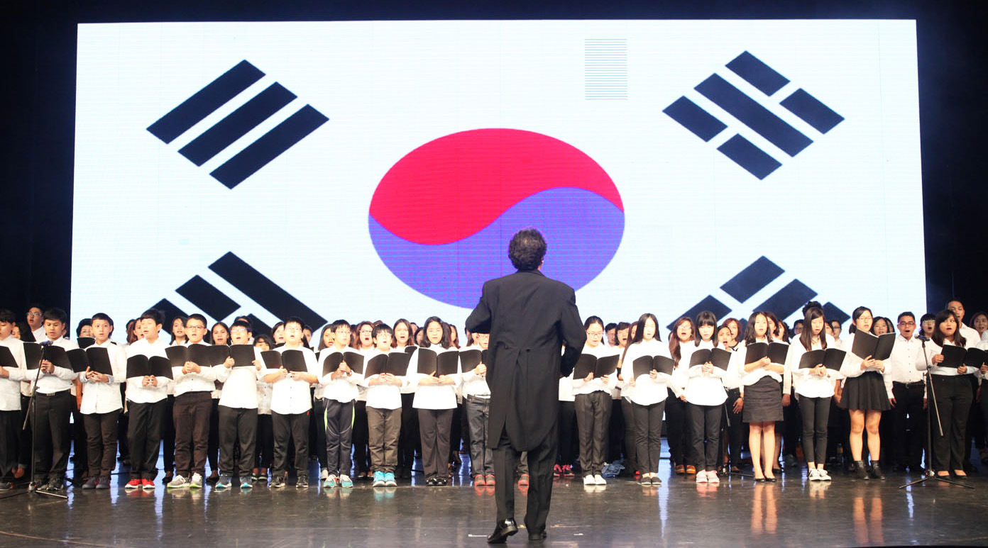 태극기가 영상에 나오며 한국 국가를 합창하는 한-필 연합 합창단의 모습