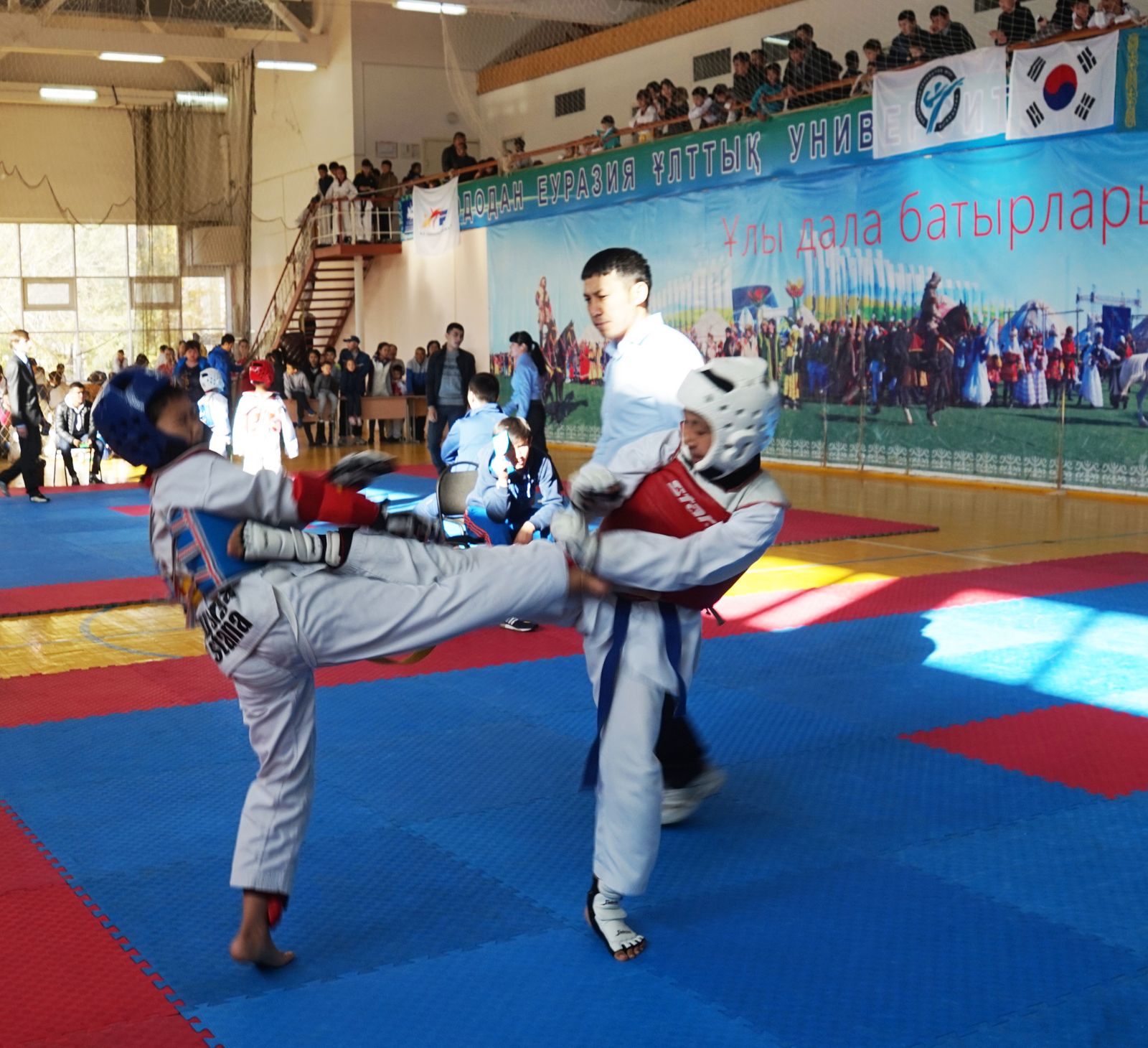 격렬하게 시합 중인 태권도 선수들의 모습.