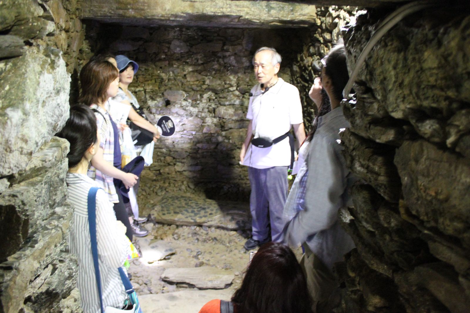 이노쿠마 가네가츠 오사카왔소문화교류협회 이사장이 이와세천총고분군 석실 내부에 들어가 직접 손으로 짚어가며 축조 기술을 설명하고 있다.