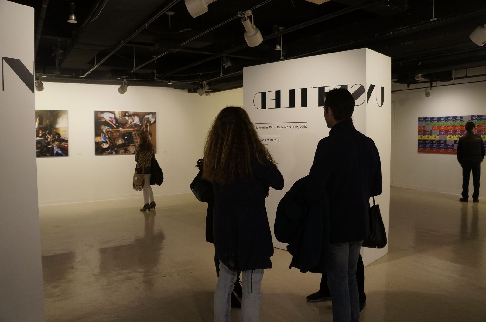 'Unsettled' 공모전 가운데 정면에 걸려있는 본인의 작품을 감상하고 있는 관람객의 모습을 파블로 작가와 그의 지인이 바라보고 있다. 