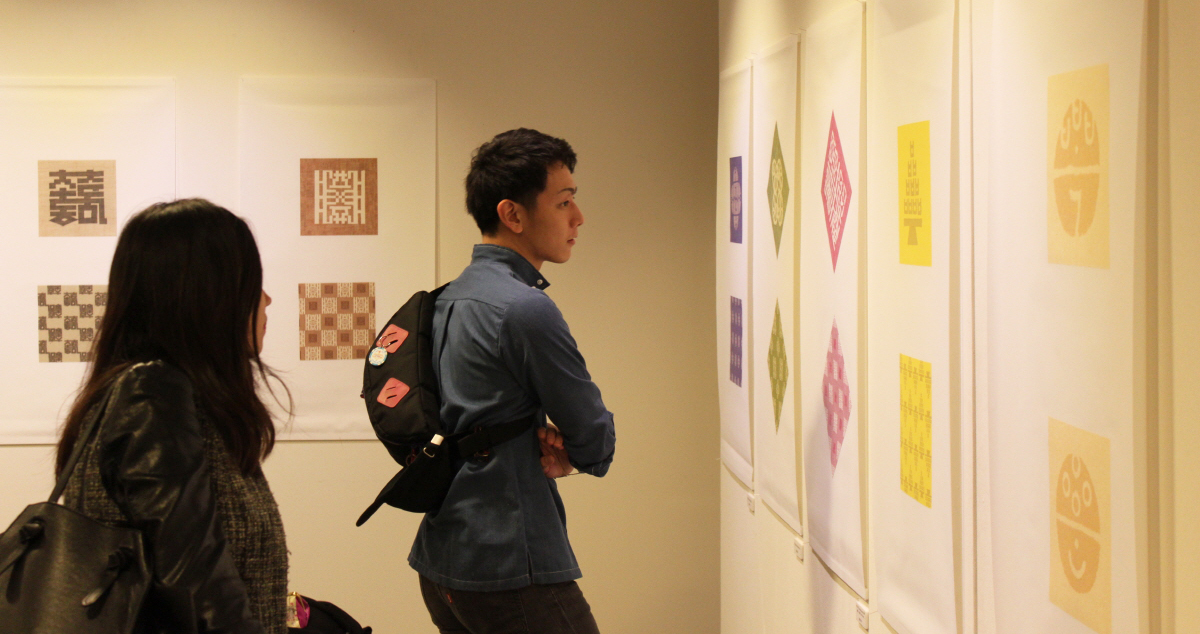 주오사카 한국문화원을 방문한 관람객들이 전통과 현대를 아우르는 한글의 가능성을 담고 있는 타이포그래피 작품을 감상 중이다.