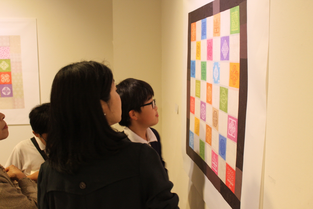 주오사카 한국문화원을 방문한 관람객들이 전통과 현대를 아우르는 한글의 가능성을 담고 있는 타이포그래피 작품을 감상 중이다.