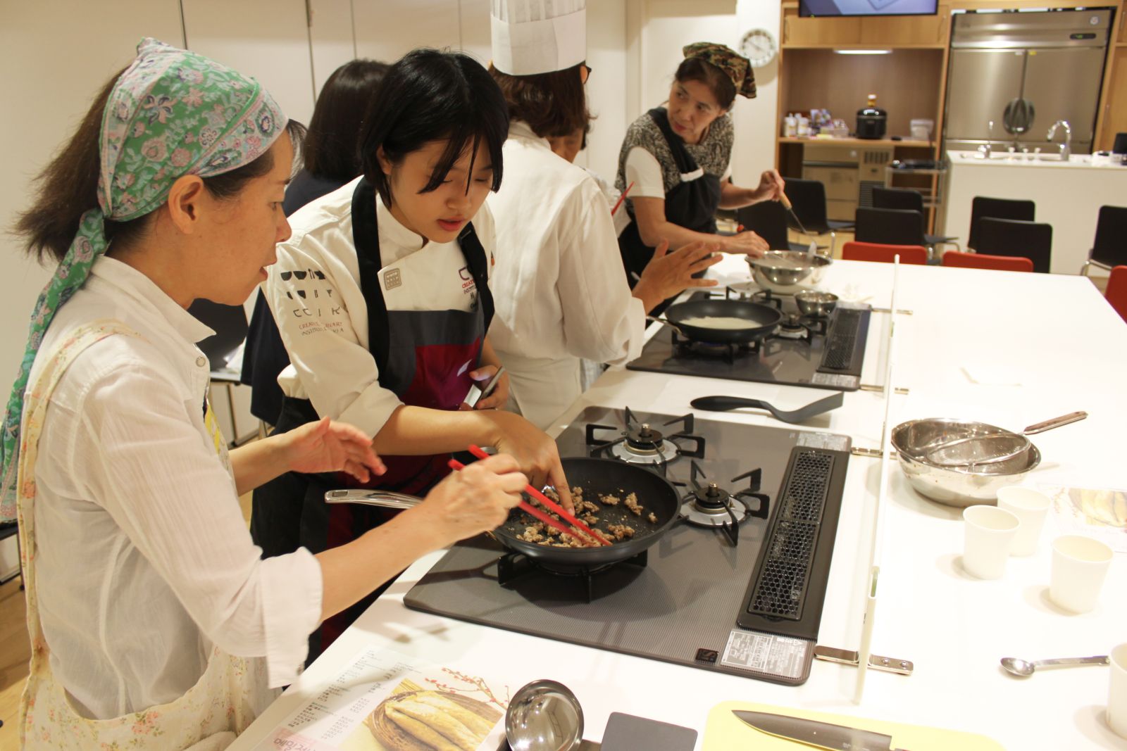 곤드레 나물과 김치를 올린 메밀전병을 만드는 참가자들을 주오사카 한국문화원의 강사진이 돕고 있다.