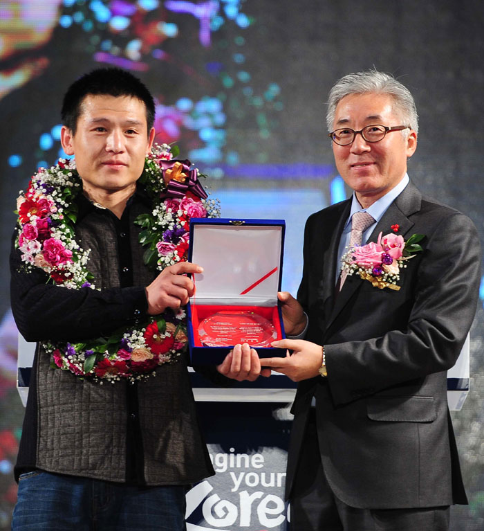 29일 김종덕 문화체육관광부 장관(오른쪽)이 한국을 찾은 1천4백만명째 외국인 관광객인 리우스취엔씨에게 꽃다발을 전달한 후 기념촬영을 하고 있다.