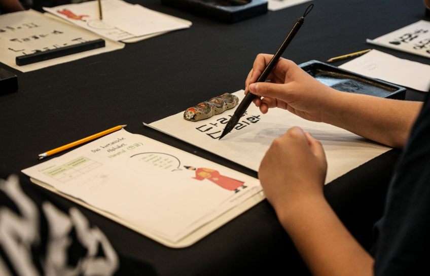 직접 한글 붓글씨를 써보는 학생들