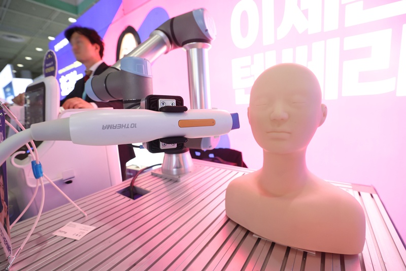 ▲ '코리아 에스테틱스 2024 대한레이저피부모발학회 선진미용의료기기전시회'가 지난해 5월 코엑스에서 열렸다. 사진은 리프팅 시술을 하는 로봇을 시연하는 모습. 연합뉴스