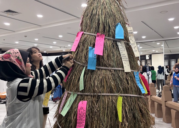 정월대보름 달집에 소원지를 달고 있는 장면