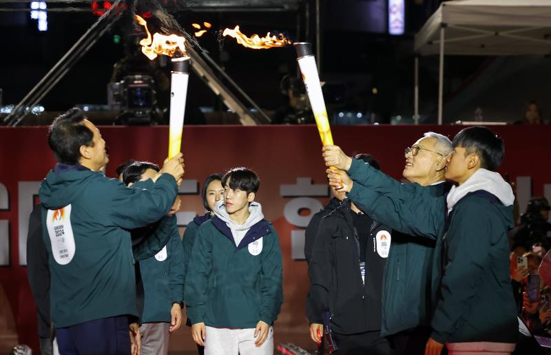 ▲ 유인촌 문체부 장관(오른쪽 두 번째)이 11일 서울 중구 서울광장에서 열린 2024강원동계청소년올림픽 G-100 기념행사에서 오세훈 서울시장(왼쪽 첫 번째)에게 성화를 인계 받고 있다. 