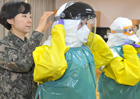 국군간호사관학교 관계자들이 에볼라 대응 긴급구호대원들이 시에라리온 치료소에서 입을 방호복을 착용하고 있다.
